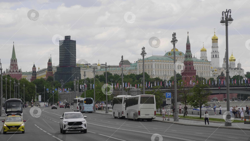 Скачать 23 июня 2025 года, Россия, Москва. Вид на Кремль с Кремлевской набережной, демонстрирующий историческую архитектуру, набережную и городской пейзаж столицы. фотосток Ozero
