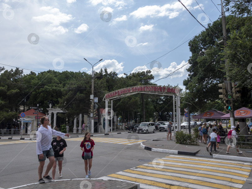 Скачать 24 августа 2025 года: Входная арка рядом с автобусной станцией в центре села Кабардинка, Россия, с табличкой "Кабардинка приветствует вас", представляющей достопримечательность села и местные пейзажи. фотосток Ozero