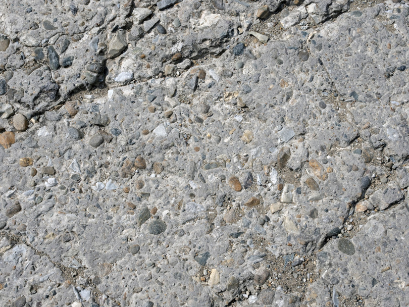 Скачать Крупный план текстуры натурального камня, детализирующий поверхность камня и его шероховатую структуру, подходит в качестве фона или абстрактного природного узора. фотосток Ozero