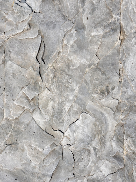 Скачать Крупный план текстуры натурального камня, детализирующий поверхность камня и его шероховатую структуру, подходит в качестве фона или абстрактного природного узора. фотосток Ozero