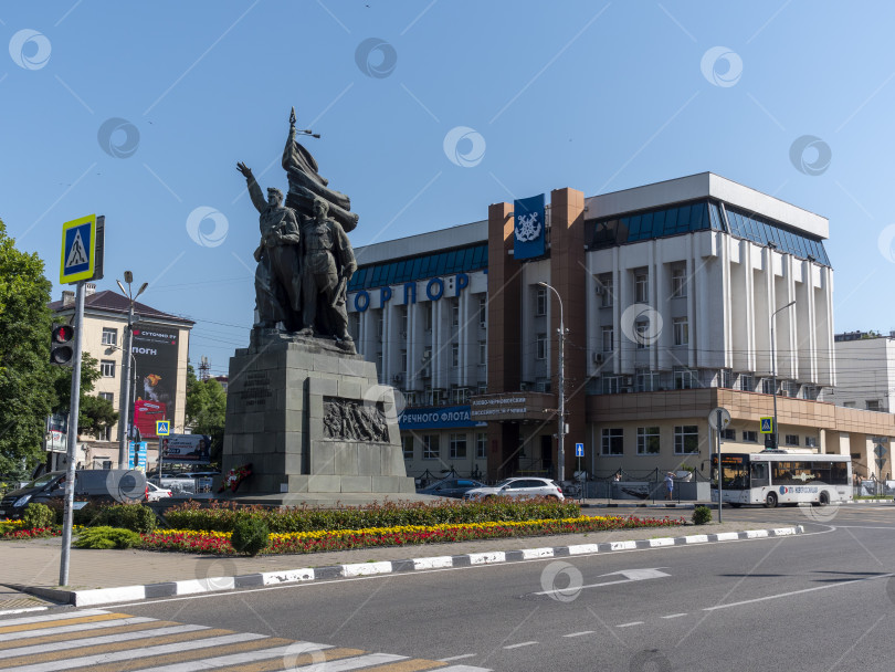 Скачать 12 августа 2025 года: Площадь Свободы в Новороссийске, Россия, центральное общественное пространство, где люди передвигаются по городу в лучах летнего солнца. фотосток Ozero