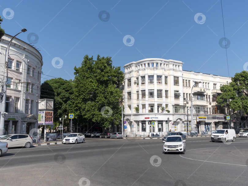 Скачать 12 августа 2025 года: Площадь Свободы в Новороссийске, Россия, центральное общественное пространство, где люди передвигаются по городу в лучах летнего солнца. фотосток Ozero