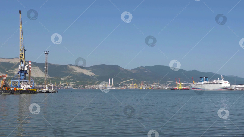 Скачать 22 августа 2025 года, вид порта Новороссийск, Россия, с грузовыми судами и кранами на побережье. Промышленный морской пейзаж на Черном море фотосток Ozero