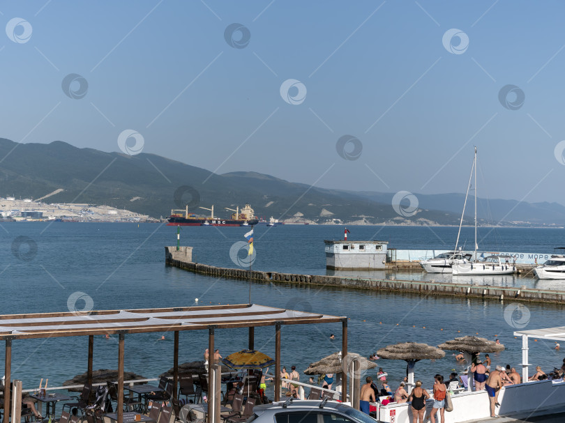 Скачать 12 августа 2025 года: Грузовое судно MSC Pamira III заходит в порт Новороссийск, Россия, двигаясь по спокойным водам на фоне оживленной портовой жизни. фотосток Ozero