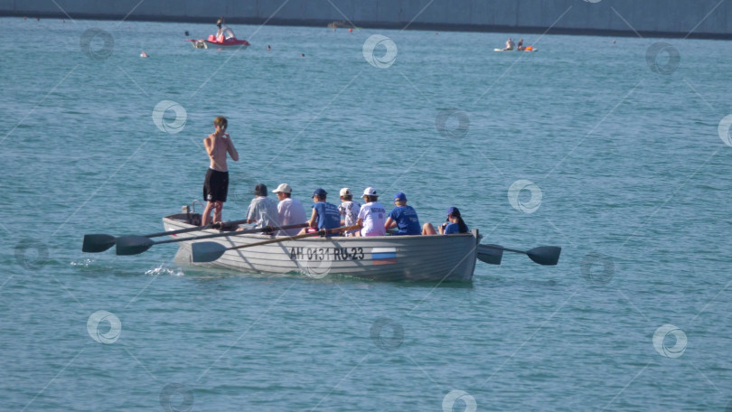 Скачать 12 августа 2025 года: Гребная лодка с подростками тренируется на воде фотосток Ozero