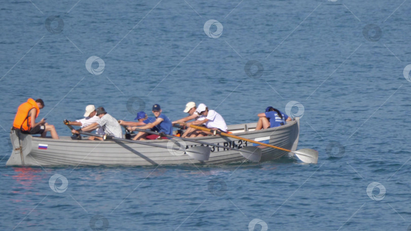 Скачать 12 августа 2025 года: Гребная лодка с подростками тренируется на воде фотосток Ozero