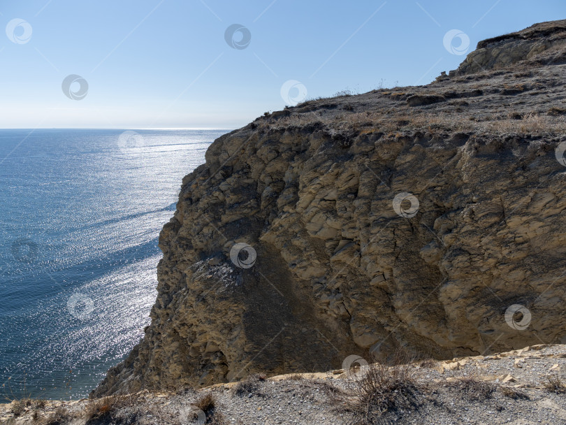 Скачать Скалистое побережье Черного моря с отвесными скалами и ясным небом, естественный морской пейзаж фотосток Ozero