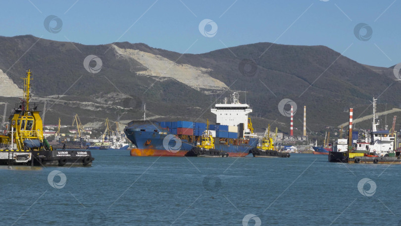 Скачать 24 августа 2025 года: Крупное грузовое судно заходит в порт Новороссийска, Россия, на Черном море, демонстрируя морской транспорт, промышленное судоходство и береговую инфраструктуру. фотосток Ozero