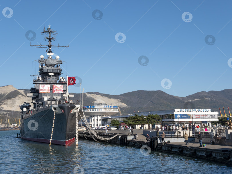 Скачать 22 августа 2025 года Памятник жене моряка на площади в Новороссийске Россия на фоне авианосца Адмирал Кузнецов виднеющегося на побережье Черного моря фотосток Ozero