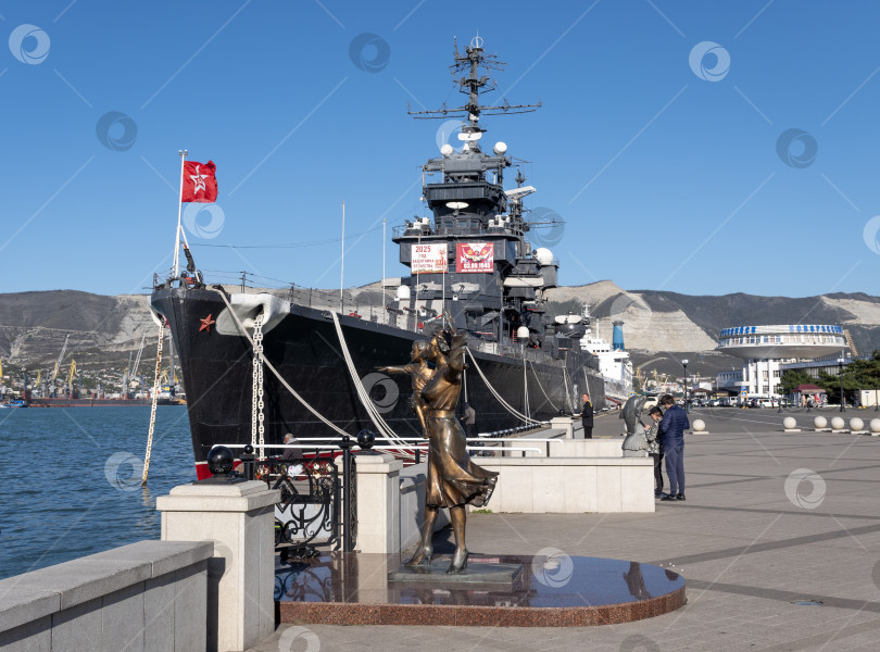 Скачать 22 августа 2025 года Памятник жене моряка на площади в Новороссийске Россия на фоне авианосца Адмирал Кузнецов виднеющегося на побережье Черного моря фотосток Ozero