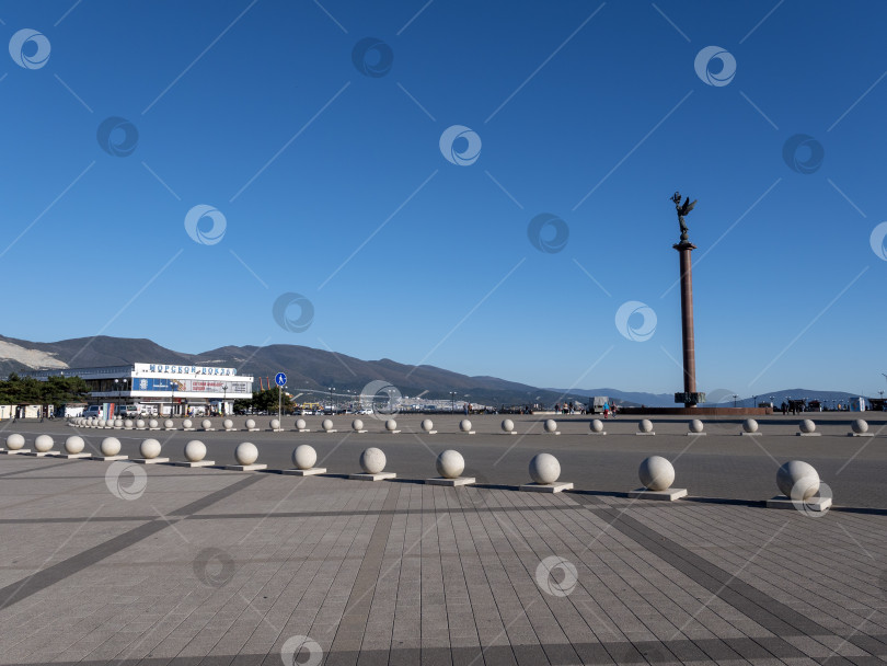 Скачать 22 августа 2025 года площадь с памятной стелой перед Морским терминалом в Новороссийске, Россия, на побережье Черного моря. Городское общественное пространство и морская достопримечательность фотосток Ozero