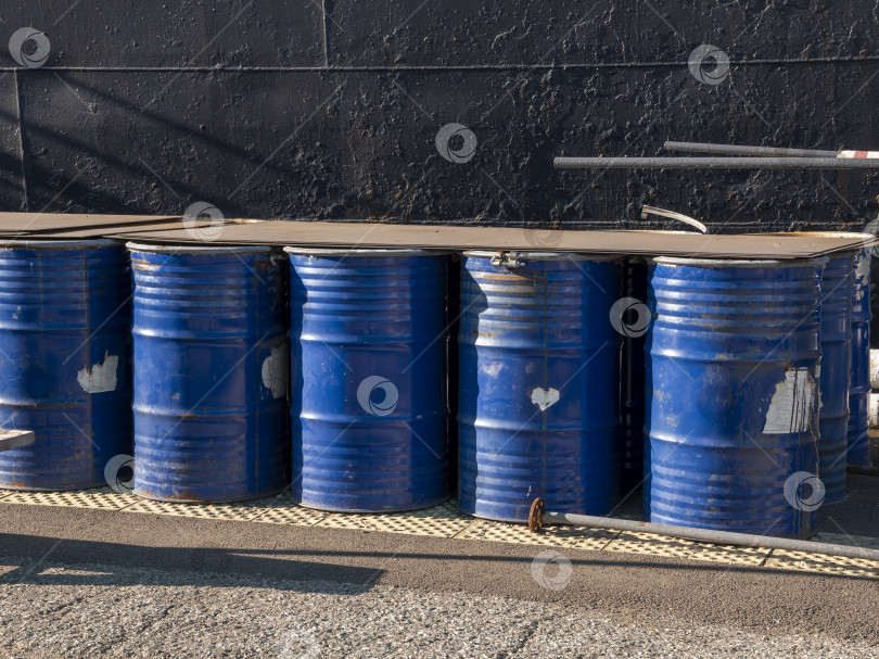 Скачать Штабель синих металлических бочек на открытом воздухе. Промышленное хранение стальных бочек в организованном штабеле фотосток Ozero