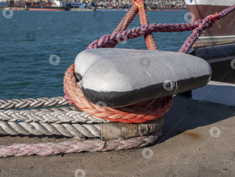 Скачать Швартовный трос, привязанный к причалу на берегу. Корабельный трос, прикрепленный к причалу в форме гриба фотосток Ozero