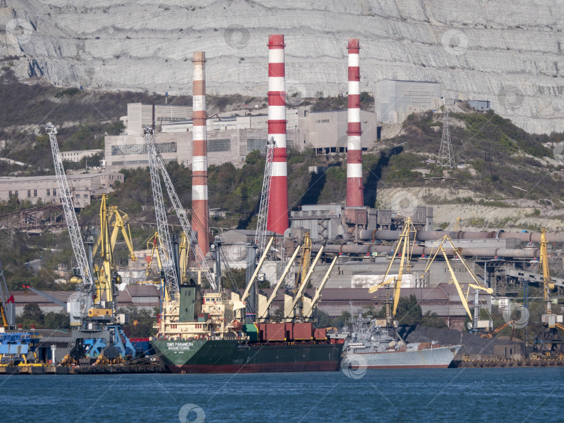 Скачать 22 августа 2025 года, вид порта Новороссийск, Россия, с грузовыми судами и кранами на побережье. Промышленный морской пейзаж на Черном море фотосток Ozero