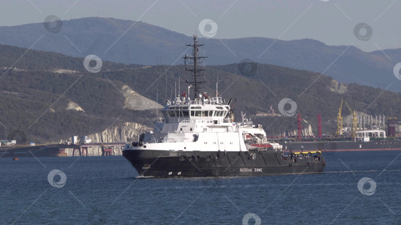 Скачать 24 августа 2025 года: Спасательные суда пришвартовались в порту Новороссийска, Россия, на фоне гор, иллюстрирующих безопасность на море, портовые операции и деятельность на побережье Черного моря. фотосток Ozero