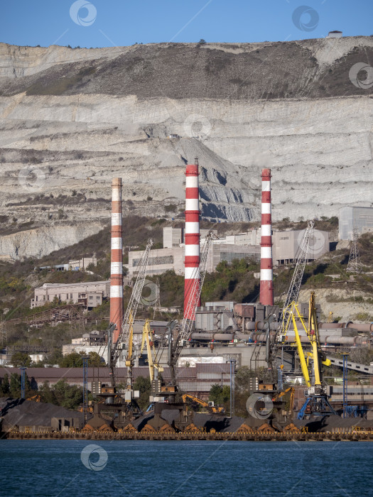 Скачать 22 августа 2025 года, вид порта Новороссийск, Россия, с грузовыми судами и кранами на побережье. Промышленный морской пейзаж на Черном море фотосток Ozero