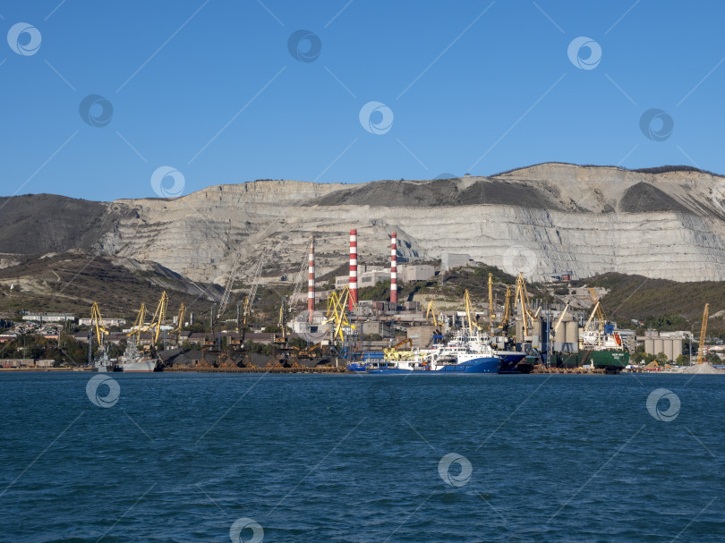 Скачать 22 августа 2025 года, вид порта Новороссийск, Россия, с грузовыми судами и кранами на побережье. Промышленный морской пейзаж на Черном море фотосток Ozero