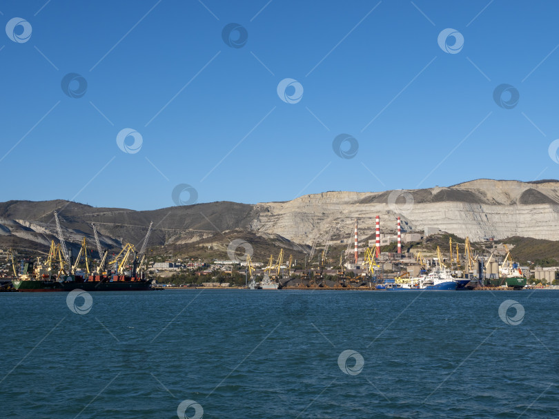 Скачать 22 августа 2025 года, вид порта Новороссийск, Россия, с грузовыми судами и кранами на побережье. Промышленный морской пейзаж на Черном море фотосток Ozero