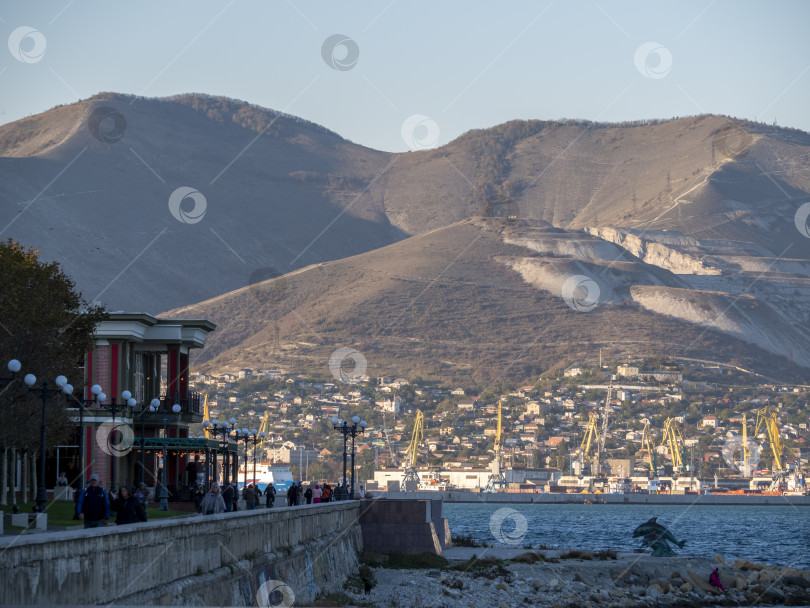 Скачать 22 августа 2025 года Вид на набережную и порт Новороссийска, Россия, на Черном море. Промышленная и городская сцена на побережье с кораблями и кранами фотосток Ozero