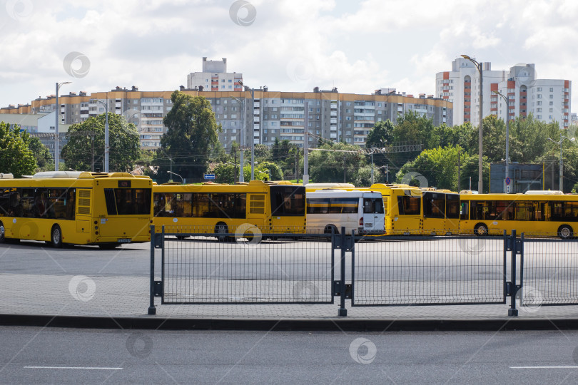 Скачать Беларусь, Минск - 21.07.2025: Вагоны дисциплинированно выстроились в линию на территории промышленного склада, окруженного ограждением и воздушными проводами фотосток Ozero
