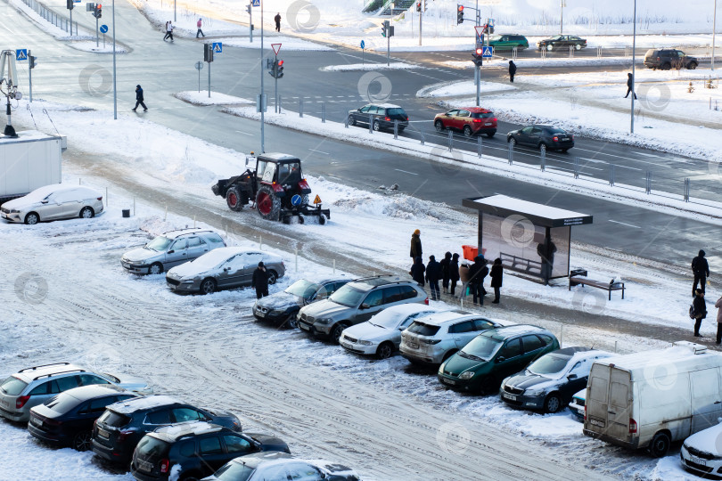 Скачать Беларусь, Минск - 10.01.2026: Заснеженная автостоянка с автомобилями, транспортными средствами и работниками в морозную зимнюю погоду фотосток Ozero