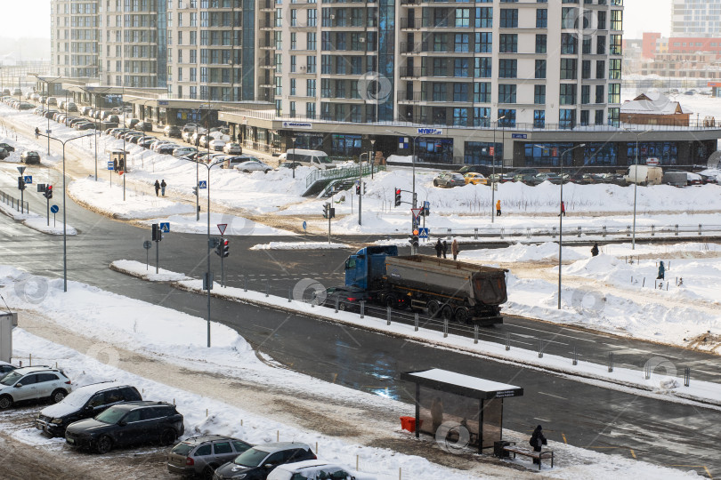 Скачать Беларусь, Минск - 25/01/2026: Городская зимняя уборка, муниципальный работник проводит зимнюю уборку возле остановок общественного транспорта фотосток Ozero