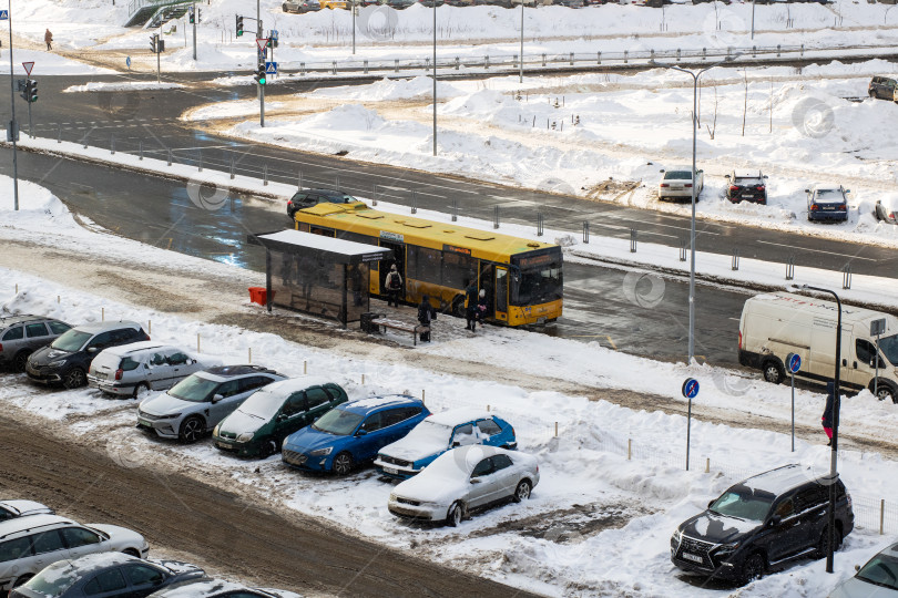 Скачать Беларусь, Минск - 25/01/2026: Городской транспорт в условиях зимнего снегопада, автобусы и припаркованные автомобили в обледенелой городской зимней обстановке фотосток Ozero