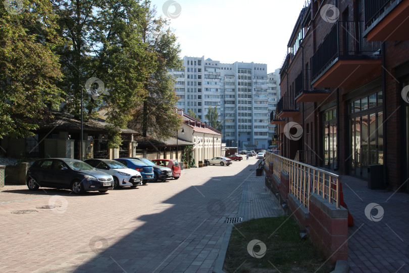 Скачать Беларусь, Минск - 22.09.2024: Яркая уличная сцена. Мирная уличная сцена, показывающая городские дома и высотные здания вдалеке. фотосток Ozero