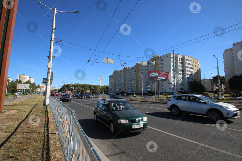 Скачать Беларусь, Минск - 22.09.2024: Широкая городская дорога заполнена машинами. Оживленная городская улица с движущимися транспортными средствами и пешеходами фотосток Ozero