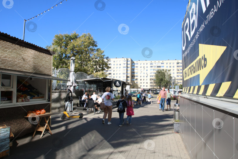 Скачать Беларусь, Минск - 22.09.2024: Семьи осматривают уличные продуктовые лавки. Дети с рюкзаками возле продавцов продуктов фотосток Ozero