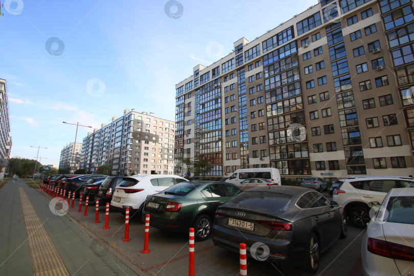 Скачать Беларусь, Минск - 22.09.2024: Припаркованные транспортные средства вдоль многоквартирной улицы. Жилая улица с автомобилями и городскими достопримечательностями фотосток Ozero