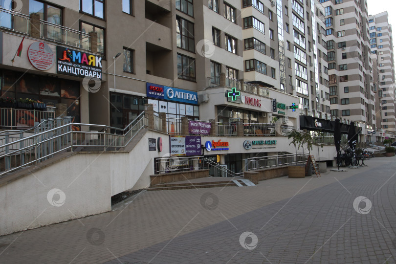 Скачать Беларусь, Минск - 22.09.2024: Современные магазины на улицах города. Торговый центр города с пешеходными дорожками и вывесками на витринах фотосток Ozero