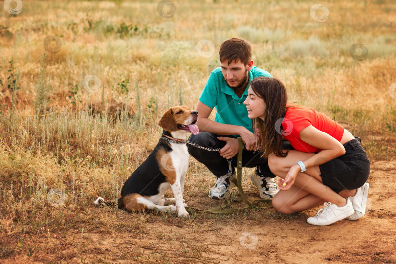 Скачать Любящие хозяева выгуливают собаку на свежем воздухе фотосток Ozero