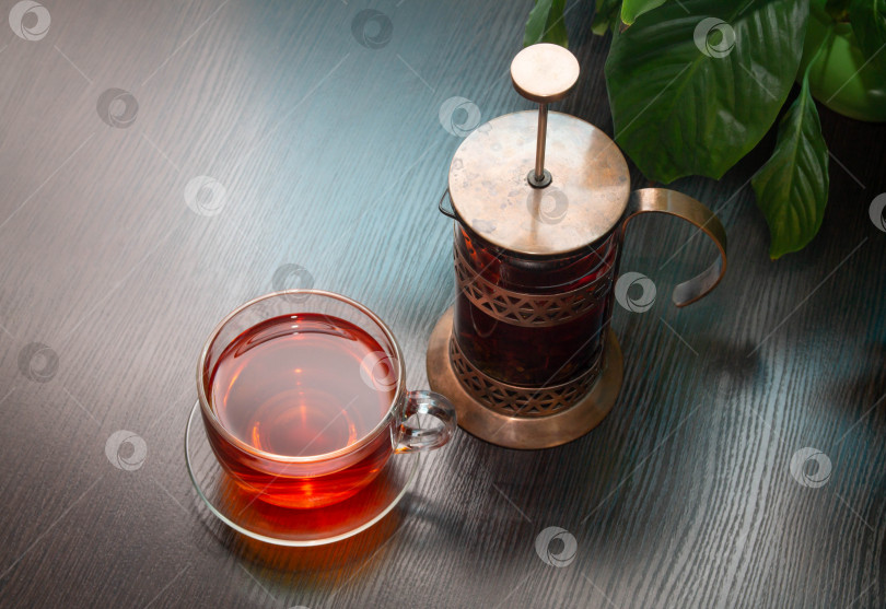 Скачать на столе горячий заваренный черный чай в заварочном чайнике и кружке фотосток Ozero