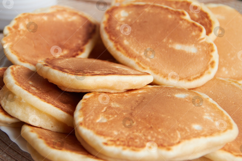 Скачать Стопка пышных золотистых блинчиков на тарелке фотосток Ozero