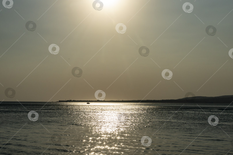 Скачать Серебристое спокойное Черное море на закате. Солнечная дорожка на воде делает пейзаж умиротворяющим и волшебным. фотосток Ozero