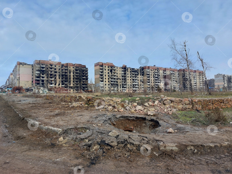 Скачать Угледар, ДНР, Российская Федерация - 30 январь 2025 : Воронка от взрыва перед рядом разрушенных многоэтажных домов фотосток Ozero