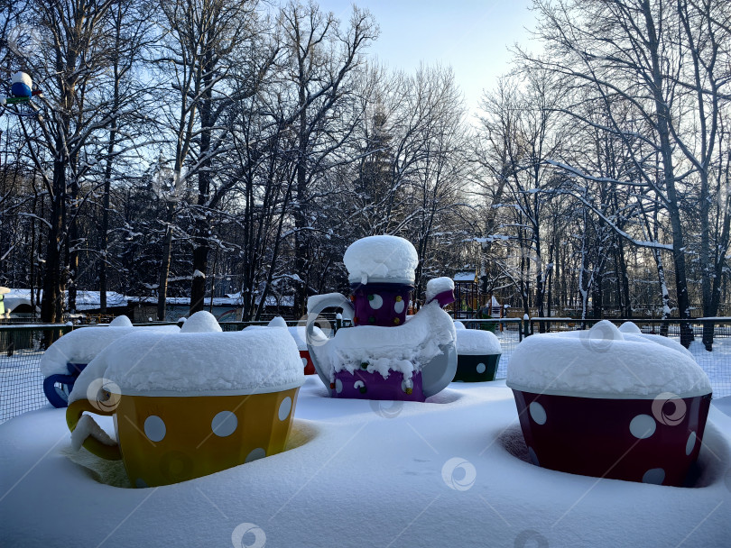 Скачать Детские карусели "Чашки", занесенные снегом фотосток Ozero