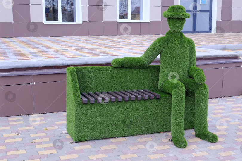 Скачать Фигура горожанина в шляпе на скамье на площади города. фотосток Ozero