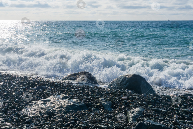 Скачать Волны разбиваются о галечный пляж с камнями фотосток Ozero