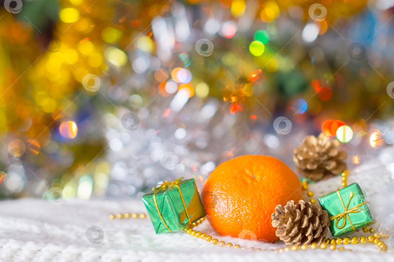 Скачать Апельсин и подарки на фоне новогодней ёлки фотосток Ozero