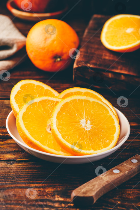 Скачать Ломтики апельсина на белой тарелке фотосток Ozero