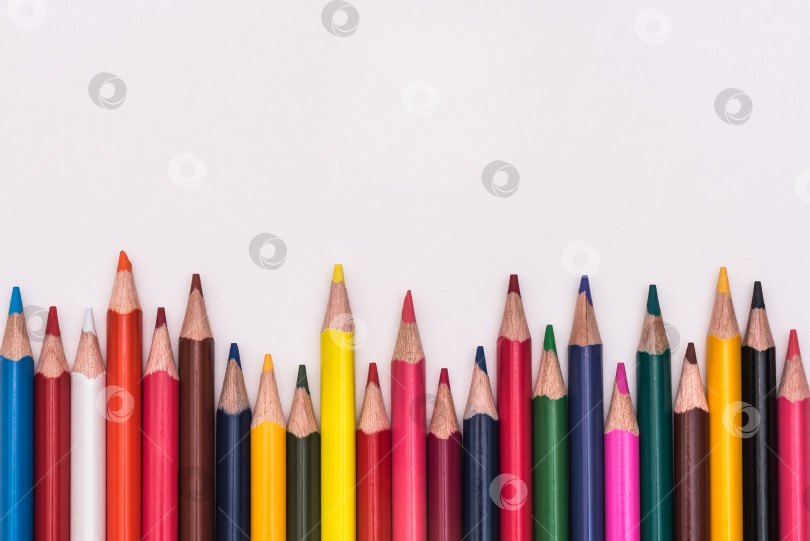 Скачать Цветные карандаши радугой лежали на белом фоне фотосток Ozero