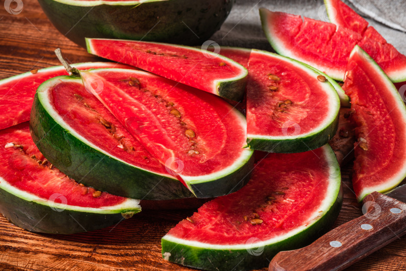 Скачать Ломтики арбуза, лежащие на деревянном столе фотосток Ozero