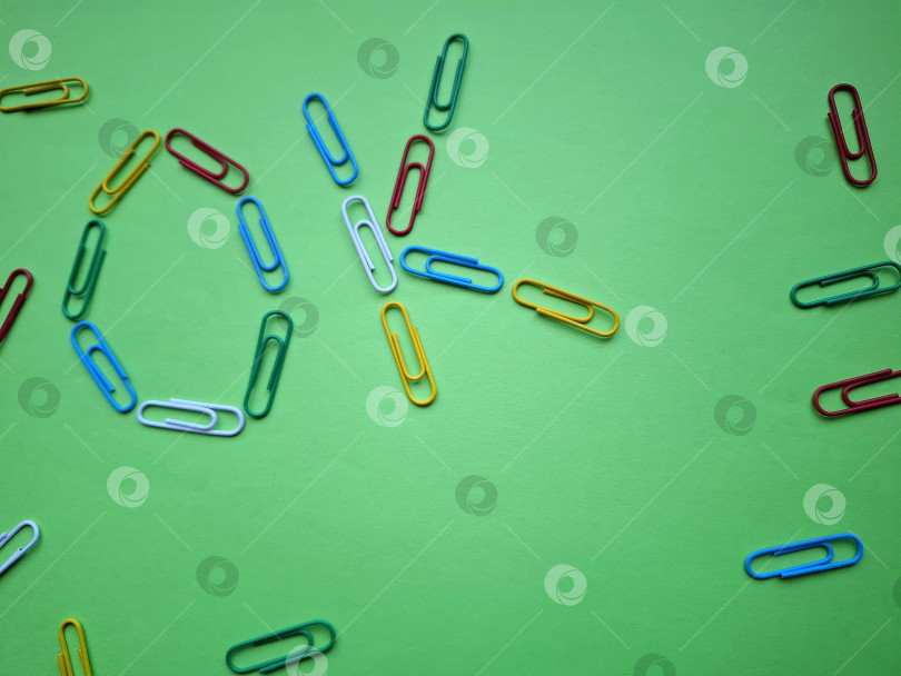 Скачать Аббревиатура "ОК"  из ярких разноцветных скрепок на зеленом фоне фотосток Ozero