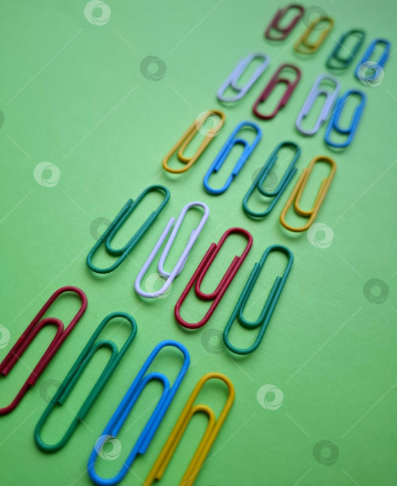 Скачать Яркие разноцветные скрепки на зеленом фоне фотосток Ozero