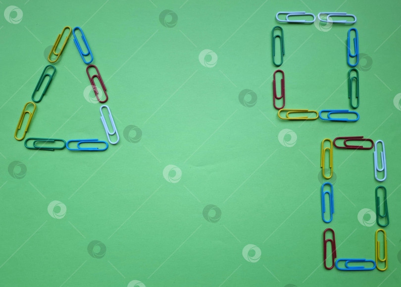 Скачать Треугольник, квадрат, прямоугольник из ярких разноцветных скрепок на зеленом фоне фотосток Ozero