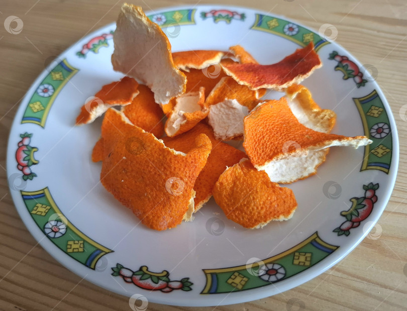 Скачать Засохшие апельсиновые и мандариновые корочки на блюдце фотосток Ozero