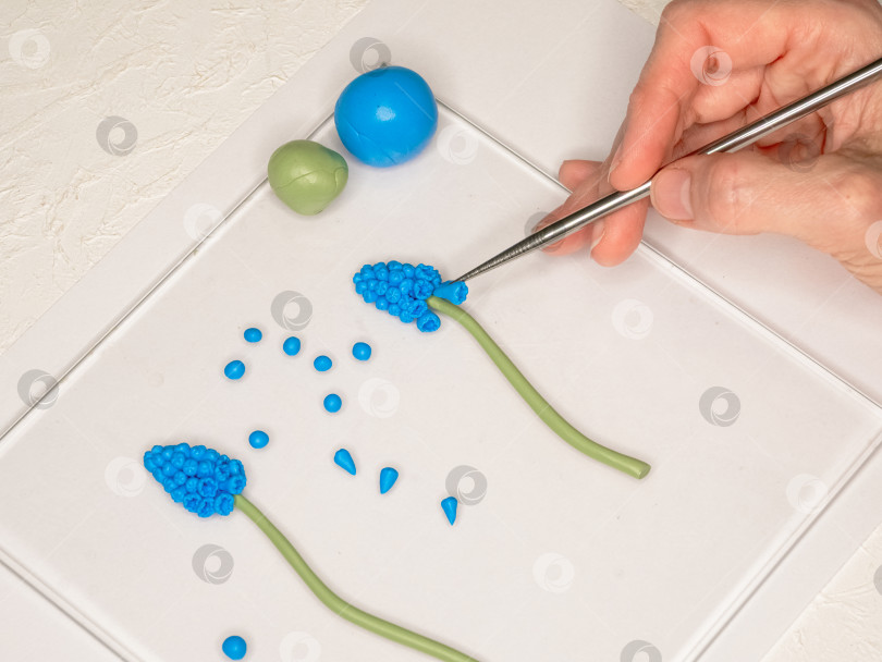 Скачать Женские руки изящно лепят цветы из полимерной глины фотосток Ozero