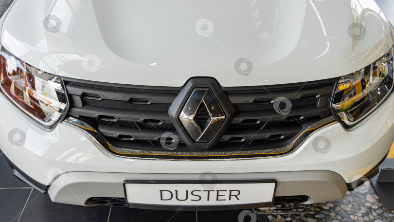 Скачать Белый внедорожник Renault Duster в дилерском центре Renault. Крупный план блестящей решетки радиатора с логотипом Renault. Автосалон Renault в Мега Адыгея. фотосток Ozero